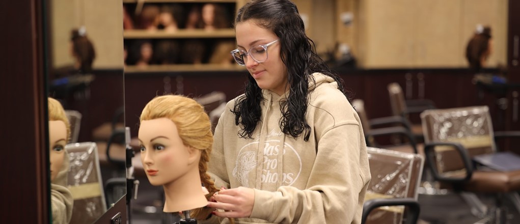 Cos student working with hair.