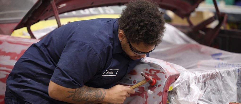 ACR student fixing dents on car